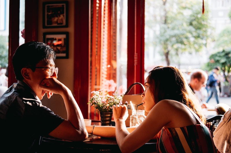 Two people talking at a European cafe